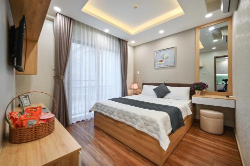 ein Schlafzimmer mit einem großen Bett und einem Spiegel in der Unterkunft Nikko Hotel - The Classy Life in Ho-Chi-Minh-Stadt