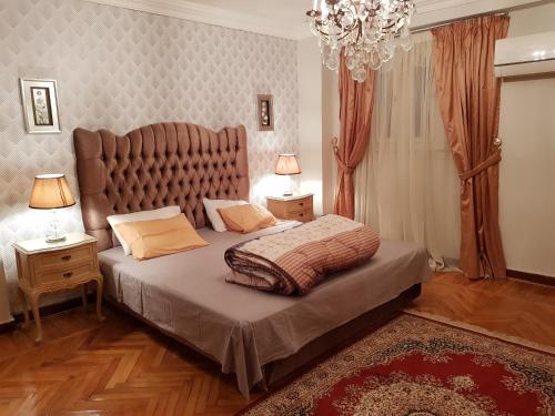 a bedroom with a large bed with a large headboard at Elite Homes 3BR Garden Apartment Families Only in 6th Of October