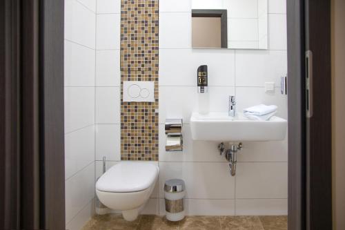 La salle de bains est pourvue de toilettes et d'un lavabo. dans l'établissement Work & Sleep Boardinghouse Mannheim, à Mannheim