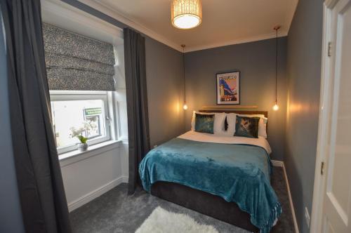 ein kleines Schlafzimmer mit einem Bett und einem Fenster in der Unterkunft The Gallery Apartment - Oban Town Centre Apartment, Walkable to Ferry Terminal in Oban