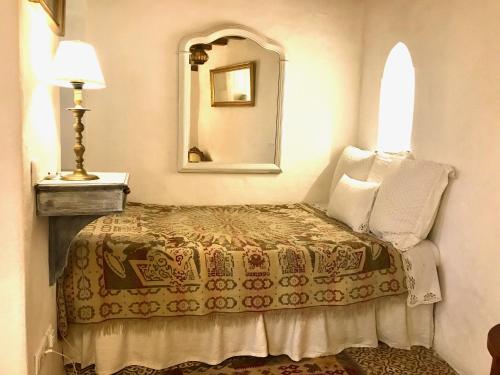 a bedroom with a bed with a mirror and a lamp at CASA DEL TEATRO Luxury Casas Vejer Debra in Vejer de la Frontera