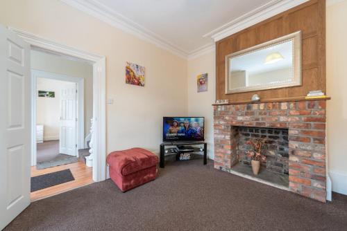 a living room with a fireplace and a tv at Thy Grace 3 Bedroom 2 Shower Room Central Location- Newland Ave in Hull