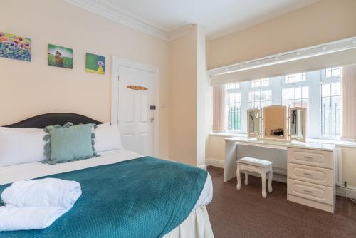 Schlafzimmer mit einem Bett und einem Schreibtisch mit einem Spiegel in der Unterkunft Thy Grace 3 Bedroom 2 Shower Room Central Location in Hull