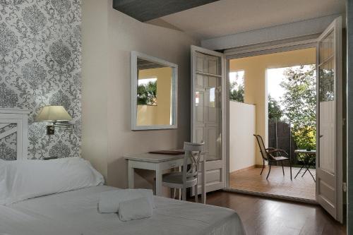 a bedroom with a bed and a table and a desk at Hotel El Castell in Sant Boi del Llobregat