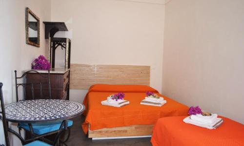 a room with two beds and a table and a mirror at Horizon Pantelleria in Pantelleria