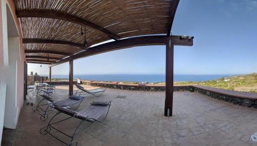 a patio with chairs and a view of the ocean at Horizon Pantelleria in Pantelleria