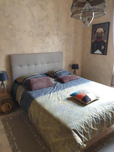 une chambre avec un grand lit avec des oreillers dessus dans l'établissement la maison porte bonheur, à Chantelle
