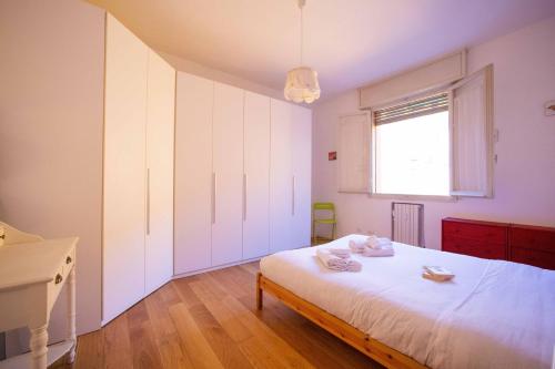una camera con un letto bianco e una finestra di GetTheKey Duse Apartment a Bologna