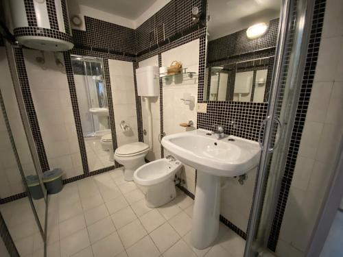 a bathroom with a sink and a toilet and a mirror at Villa Don Mimì Guarnaschelli la dependace in Taormina