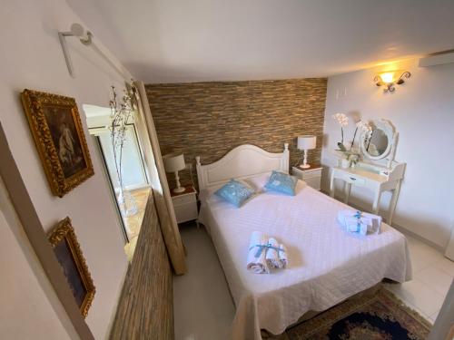 a bedroom with a bed with white sheets and blue pillows at Villa Don Mimì Guarnaschelli la dependace in Taormina