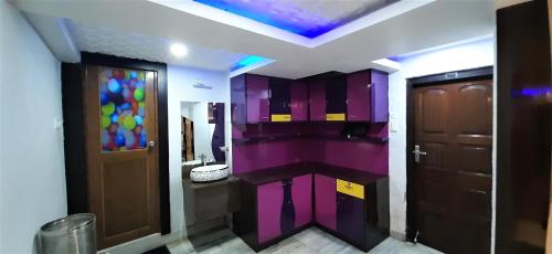 baño con paredes de color púrpura y puerta morada en DORA HOUSE, en Calcuta