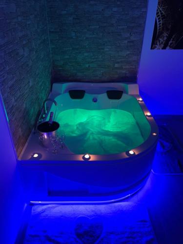 a bathroom with a green tub with lights in it at B&B La Perla & Suites in Bari