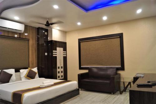 a bedroom with a bed and a chair and a screen at DORA HOUSE in Kolkata