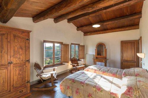 - une chambre avec un lit et deux chaises dans l'établissement Villa Cungi con piscina privata, à Misciano