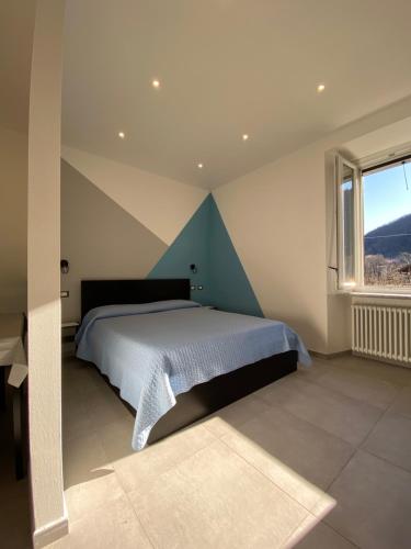 a bedroom with a bed and a large window at Azalea Appartamenti in Cannobio