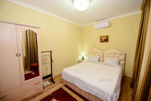 a bedroom with a white bed and a mirror at HOTEL VLADi in Kutaisi