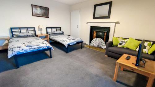- un salon avec deux lits et un canapé dans l'établissement Dunvegan House, à Helmsdale