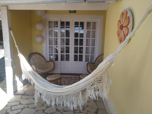 a porch with a hammock on a house at 3 Palmeiras Guest Lounge in Miguel Pereira