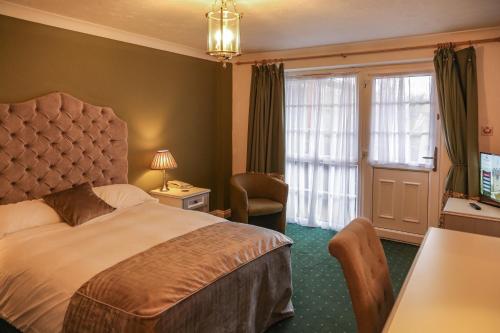 a hotel room with a bed and a desk and window at Garrison Hotel in Sheffield