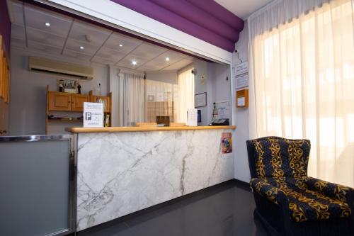 vestíbulo con barra de mármol y silla en Hotel Rosi, en Benicarló