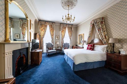 a bedroom with a king sized bed and a fireplace at The Kennard Boutique Guesthouse in Bath