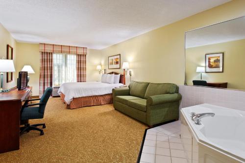 ein Hotelzimmer mit einem Bett, einem Stuhl und einem Schreibtisch in der Unterkunft Country Inn & Suites by Radisson, Elgin, IL in Elgin
