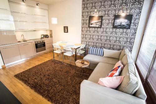 uma sala de estar com um sofá e uma mesa em Royal Parkside na Cracóvia