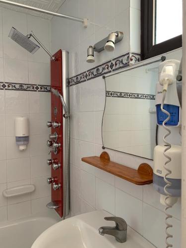 a bathroom with a sink and a shower at Hotel Patricia in Torreguadiaro