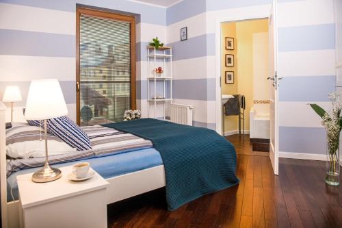 1 dormitorio con 1 cama con rayas azules y blancas en Music Apartment, en Ełk
