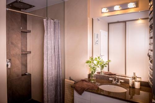 een badkamer met een wastafel en een spiegel bij Music Apartment in Ełk