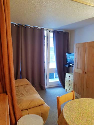 une chambre avec un lit et une fenêtre avec des rideaux dans l'établissement Studio confortable avec vue sur la montagne à Vars - 23 m², à Vars