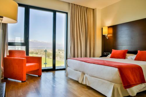 Hospedium Hotel Valles de Gredos Golf في Talayuela: غرفة فندقية بسرير ونافذة كبيرة