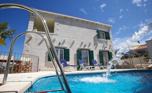 a pool with a water fountain in front of a house at Villa Angelina in Mirce