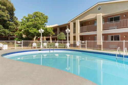 a swimming pool in front of a building at Days Inn by Wyndham Lawton in Lawton