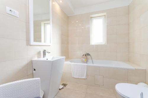 ein weißes Badezimmer mit Badewanne und Waschbecken in der Unterkunft House Andrijana in Novi Vinodolski