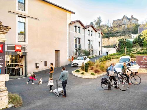 grupa ludzi stojących na parkingu w obiekcie Ibis Sarlat Centre w mieście Sarlat-la-Canéda