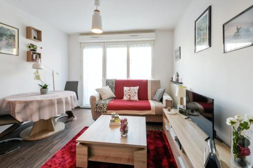 un salon avec un canapé et une table dans l'établissement Appartement charmant à Rouen, 40 m², balcon et vue sur la ville., à Rouen