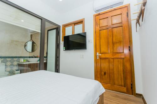 a bedroom with a bed and a wooden door at SOLEIL BOUTIQUE in Hue