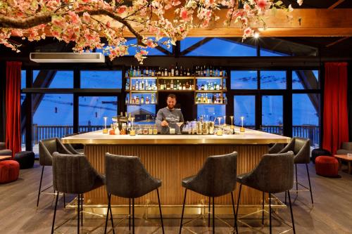 a man sitting at a bar in a restaurant at Hôtel Marielle in Val Thorens