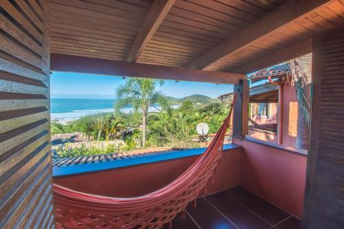 een hangmat in een kamer met uitzicht op de oceaan bij Pousada Villa Agrifoglio in Praia do Rosa