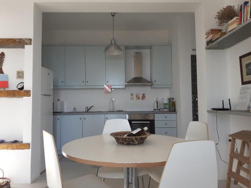 a kitchen with white cabinets and a table and chairs at Katoikia Spathi in Spathi 