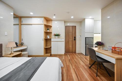 een slaapkamer met een bed, een bureau en een keuken bij Nikko Hotel - The Classy Life in Ho Chi Minh-stad