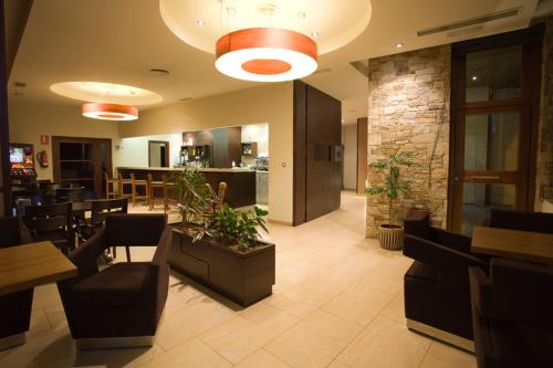 ein Restaurant mit einer Lobby mit Tischen und Stühlen in der Unterkunft Hotel Mar de Plata in Sarria