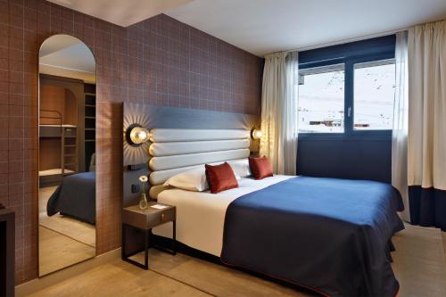 a hotel room with a bed and a mirror at Hôtel Marielle in Val Thorens