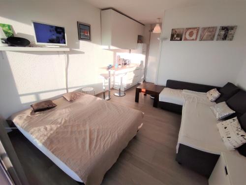 une petite pièce avec un lit et un canapé dans l'établissement ꔣᨐ La mer au bout du jardin - Parking privé - Wifi ᨐꔣ, à La Grande Motte