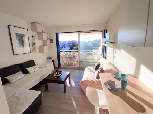 un salon avec un canapé et une table dans l'établissement ꔣᨐ La mer au bout du jardin - Parking privé - Wifi ᨐꔣ, à La Grande Motte