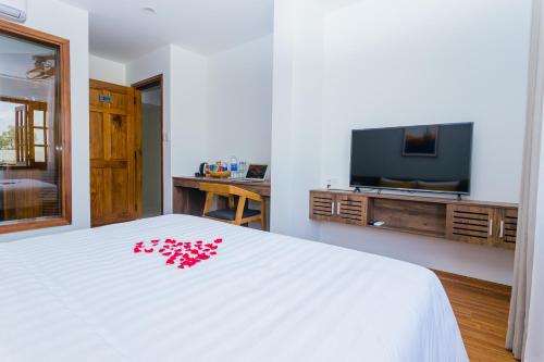 a bedroom with a white bed with red flowers on it at SOLEIL BOUTIQUE in Hue