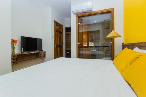 a bedroom with a white bed and a television at SOLEIL BOUTIQUE in Hue