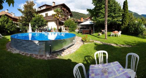 a backyard with a swimming pool and a house at Gasthaus Abram in Auer