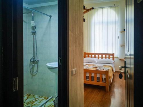 a bathroom with a bed and a sink and a shower at 1870 Hotel in Kutaisi
